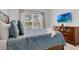 Bright bedroom featuring a TV, a comfortable bed with decorative pillows and linens, and a dresser at 4403 Scene Ln, Kissimmee, FL 34746