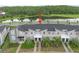 An aerial view of a modern townhome with gray facade, dark roof, and manicured landscaping near a serene pond at 4403 Scene Ln, Kissimmee, FL 34746