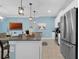 Sleek kitchen featuring stainless steel appliances, white cabinets, a breakfast bar, and modern pendant lighting at 4403 Scene Ln, Kissimmee, FL 34746