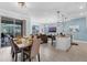 Open-concept living space with a modern kitchen, dining area, comfortable living room, and sliding glass doors at 4403 Scene Ln, Kissimmee, FL 34746