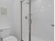 Modern walk-in shower with clear glass doors and white tile and a white toilet at 4403 Scene Ln, Kissimmee, FL 34746