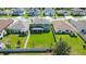 Aerial view of a green lawn, fenced backyard, and screened in lanai surrounded by neighborhood homes at 454 Sunfish Dr, Winter Haven, FL 33881