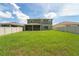 Expansive backyard showcasing the home's exterior with a covered patio and a lush, green lawn at 454 Sunfish Dr, Winter Haven, FL 33881