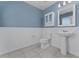 Charming powder room with a pedestal sink, tiled floors, wainscoting, and a decorative mirror at 454 Sunfish Dr, Winter Haven, FL 33881