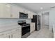 Modern kitchen with stainless steel appliances, white cabinetry, and ample counter space for cooking at 454 Sunfish Dr, Winter Haven, FL 33881
