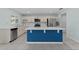 Spacious kitchen with white cabinetry, stainless steel appliances, a blue island, and tile flooring at 454 Sunfish Dr, Winter Haven, FL 33881