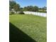 A big backyard with lush green grass enclosed by a white fence, perfect for outdoor activities at 506 Myakka Pl, Kissimmee, FL 34759