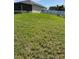 Spacious backyard with green grass, a white fence, and a screened-in porch ideal for enjoying outdoor living at 506 Myakka Pl, Kissimmee, FL 34759