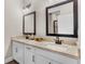 Bathroom featuring double sink vanity with granite countertops, large mirrors and great lighting at 7848 Somersworth Dr, Kissimmee, FL 34747
