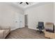 Spacious room with wood-look floors, a comfy chair, an office chair, and an open doorway at 7848 Somersworth Dr, Kissimmee, FL 34747