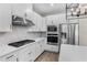 Well-equipped kitchen boasting white cabinets, quartz countertops, stainless steel appliances, and a modern gas range at 7848 Somersworth Dr, Kissimmee, FL 34747