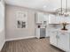 Bright kitchen featuring white cabinets, stainless steel appliances, a kitchen island, and hardwood floors, creating a modern space at 7848 Somersworth Dr, Kissimmee, FL 34747
