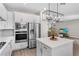 Bright, modern kitchen featuring stainless steel appliances, white cabinets, and an island with a white countertop at 7848 Somersworth Dr, Kissimmee, FL 34747