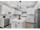 Well-lit kitchen featuring white cabinets, stainless steel appliances, a central island, and hardwood floors for a modern feel at 7848 Somersworth Dr, Kissimmee, FL 34747