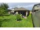 Spacious backyard with a patio, pergola, lush lawn, and privacy fence at 1456 Sourwood Dr, Ocoee, FL 34761