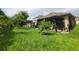 Expansive backyard featuring a patio with pergola, mature trees, and well-manicured lawn at 1456 Sourwood Dr, Ocoee, FL 34761