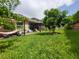Spacious backyard with a pergola-covered patio, outdoor seating, lush greenery, and ample room for recreation at 1456 Sourwood Dr, Ocoee, FL 34761