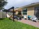 Cozy backyard patio area with comfortable seating, a hammock, and a well-manicured lawn, ideal for relaxation at 1456 Sourwood Dr, Ocoee, FL 34761