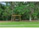 Backyard landscape showcasing a wooden swing under mature shade trees and lush lawn at 1456 Sourwood Dr, Ocoee, FL 34761