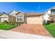 Beautiful single-Gathering home showcasing a brick driveway, manicured lawn, and a stone facade at 1456 Sourwood Dr, Ocoee, FL 34761