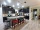 Spacious kitchen boasts a large island, stainless steel appliances, dark cabinetry, and stylish pendant lighting at 1456 Sourwood Dr, Ocoee, FL 34761