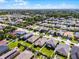 An aerial shot of the home in its residential community with green spaces and surrounding houses at 1940 Banner Ln, St Cloud, FL 34769