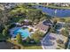 Aerial view of the community pool and clubhouse, nestled beside a scenic lake and surrounded by mature trees at 1940 Banner Ln, St Cloud, FL 34769