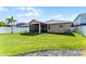 Well-maintained backyard featuring a screened-in lanai and lush green lawn, perfect for outdoor living at 1940 Banner Ln, St Cloud, FL 34769
