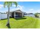Well-maintained backyard with lush green grass, a screened-in patio, and a white fence at 1940 Banner Ln, St Cloud, FL 34769