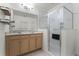 Bathroom features a double vanity, a decorative mirror, wood floating shelves, and a glass door shower at 1940 Banner Ln, St Cloud, FL 34769