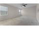 This large bedroom features neutral walls, carpet, a ceiling fan, and two windows at 1940 Banner Ln, St Cloud, FL 34769