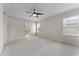 This bedroom features a ceiling fan, two windows, carpet, and an ensuite bathroom at 1940 Banner Ln, St Cloud, FL 34769