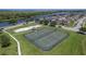Aerial view of community tennis and basketball courts, alongside a scenic lake and residential area at 1940 Banner Ln, St Cloud, FL 34769