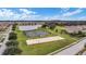 Aerial view of community amenities including a lake, tennis courts, volleyball court, and open green space at 1940 Banner Ln, St Cloud, FL 34769