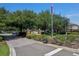 The community's entrance featuring a brick sign, mature trees, and manicured landscaping at 1940 Banner Ln, St Cloud, FL 34769