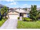 Inviting home exterior with manicured lawn, mature landscaping, and a charming front entrance at 1940 Banner Ln, St Cloud, FL 34769
