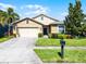 Charming single-story home with a well-manicured lawn, mature trees, and a two-car garage at 1940 Banner Ln, St Cloud, FL 34769
