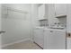 This laundry room features a white washer and dryer set, upper cabinets, and a wire rack at 1940 Banner Ln, St Cloud, FL 34769