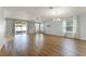 Bright living room with wood floors, ceiling fan, and sliding glass doors to the screened lanai at 1940 Banner Ln, St Cloud, FL 34769