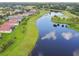 Scenic aerial view of homes nestled along a picturesque lake with golf course in background at 324 Sorrento Rd, Poinciana, FL 34759