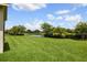 Lush green backyard with pond views, mature landscaping, and plenty of space to enjoy the outdoors at 324 Sorrento Rd, Poinciana, FL 34759