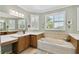 Bathroom with a soaking tub, double vanity, and a large window providing natural light at 324 Sorrento Rd, Poinciana, FL 34759