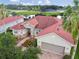 Beautiful home featuring a red roof, complemented by lush landscaping and a serene water view at 324 Sorrento Rd, Poinciana, FL 34759