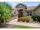 Inviting front entrance with stone accents, lush landscaping, and a charming brick walkway at 324 Sorrento Rd, Poinciana, FL 34759