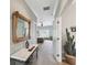 Hallway showcasing a decorative table and mirror leading to a bedroom with abundant natural light at 324 Sorrento Rd, Poinciana, FL 34759