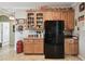 Kitchen features a modern black refrigerator, wood cabinets, and granite countertops at 324 Sorrento Rd, Poinciana, FL 34759