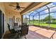 Screened lanai with a dining set and views of the lush backyard and pond at 324 Sorrento Rd, Poinciana, FL 34759
