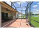 Screened lanai featuring tile floors, ceiling fan, and serene views of the lush backyard and pond at 324 Sorrento Rd, Poinciana, FL 34759
