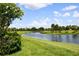 Scenic view of the tranquil pond, mature trees, and lush greenery surrounding the property at 324 Sorrento Rd, Poinciana, FL 34759