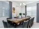 Elegant dining room with a long wooden table set for a meal, complemented by chic chairs and modern lighting at 8937 Amelia Downs Trl, Kissimmee, FL 34747